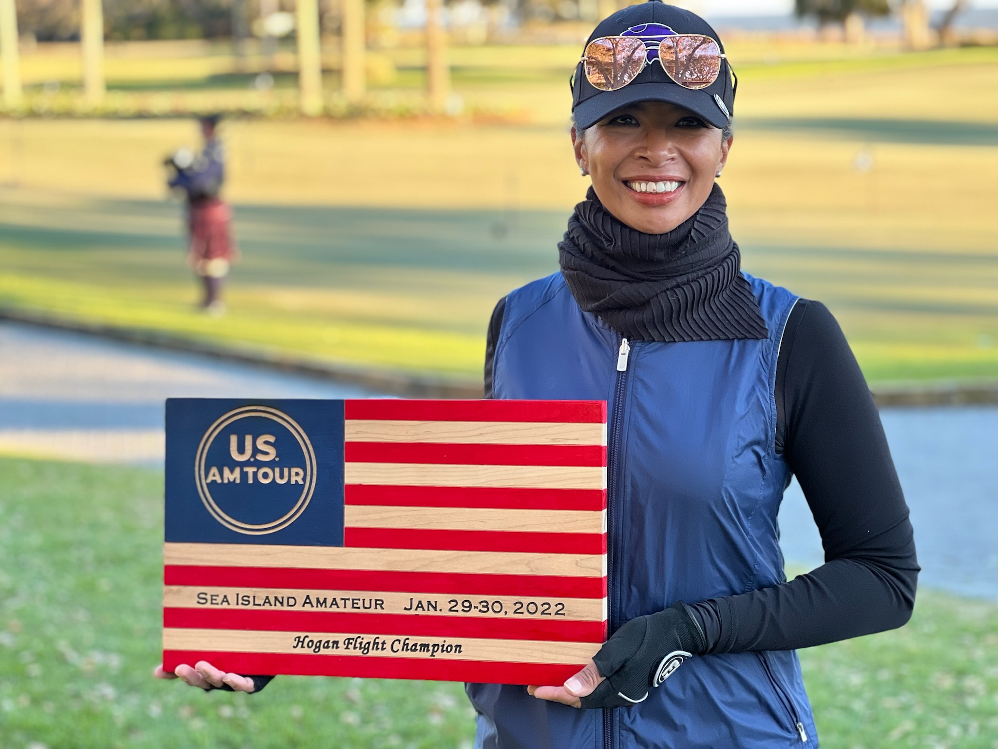Sarah Patterson on a golf course holding a Sea Island Amateur champion plaque